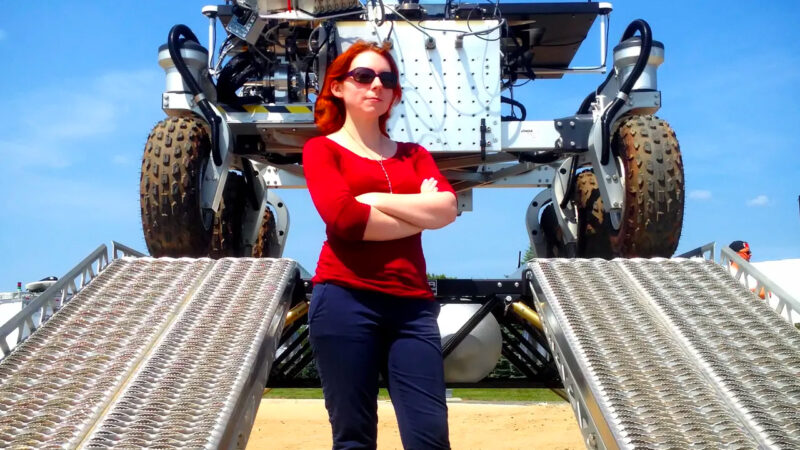 Dr. Tanya Harrison standing in front of the Canadian Space Agency's Mars Exploration Science Rover (MESR)