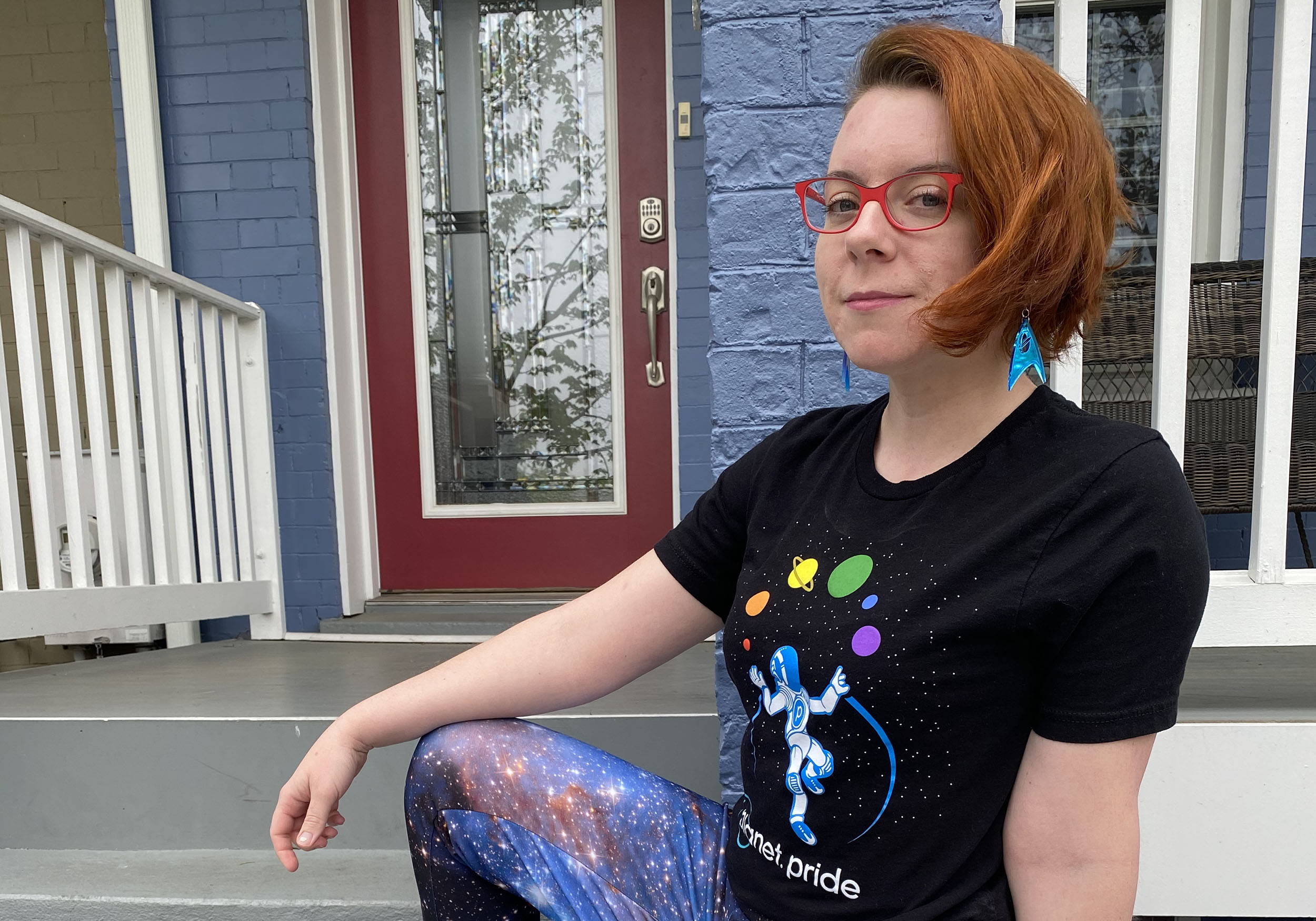 Tanya Harrison in a Planet Pride shirt and galaxy pants for Pride Month